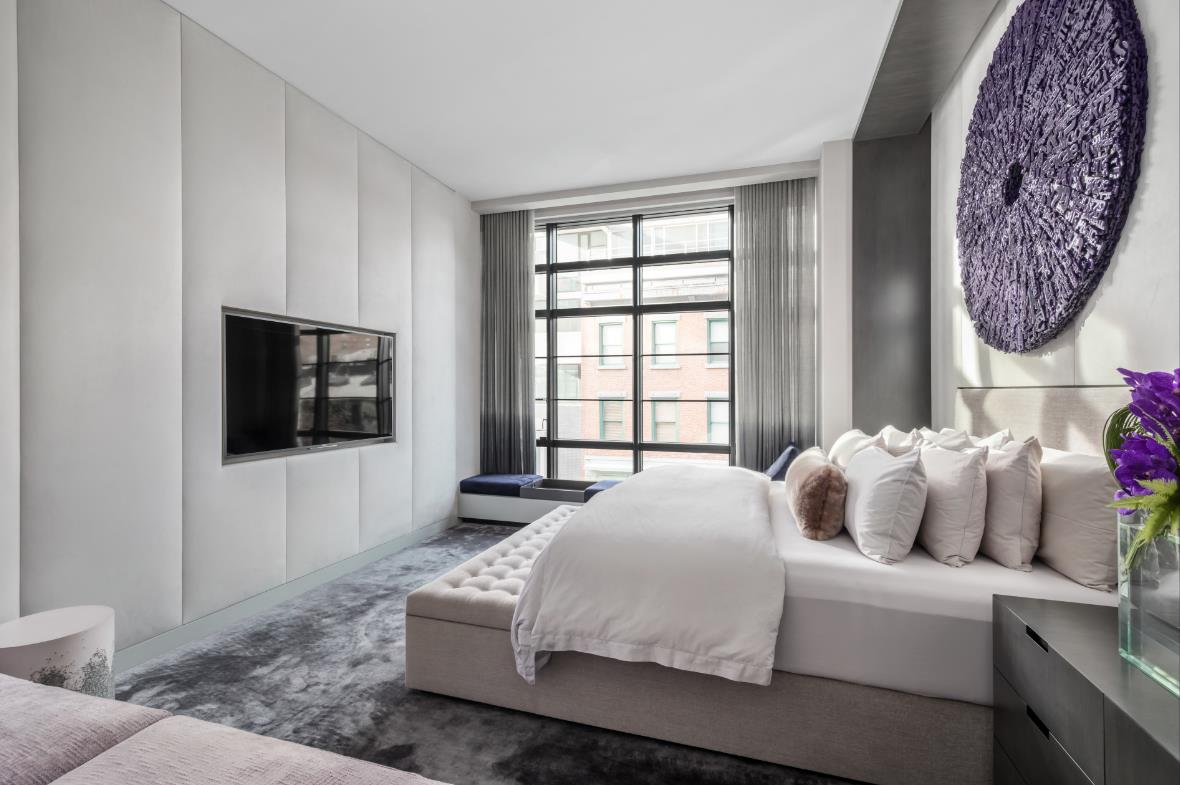 A bedroom with white and gray colors
